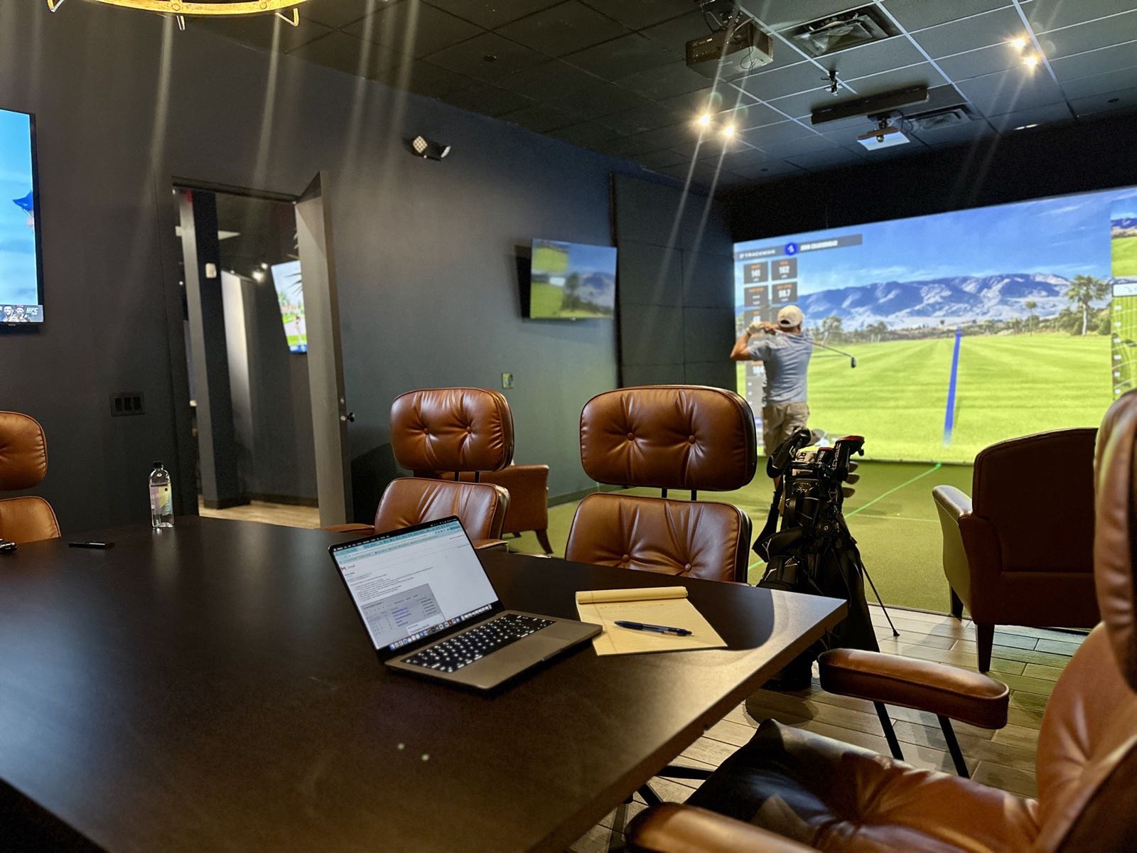 The conference room at The Office, with a member playing in the bay beyond